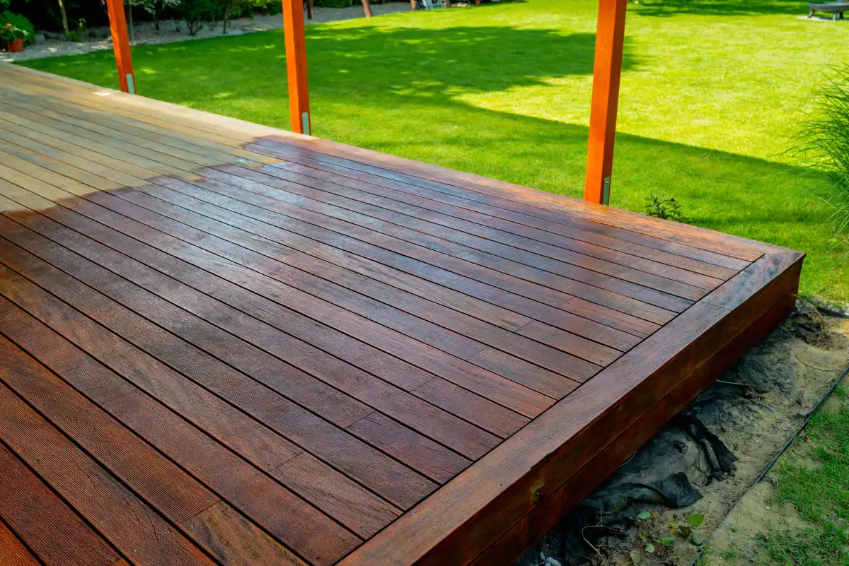Freshly stained wooden deck with rich dark finish in a backyard