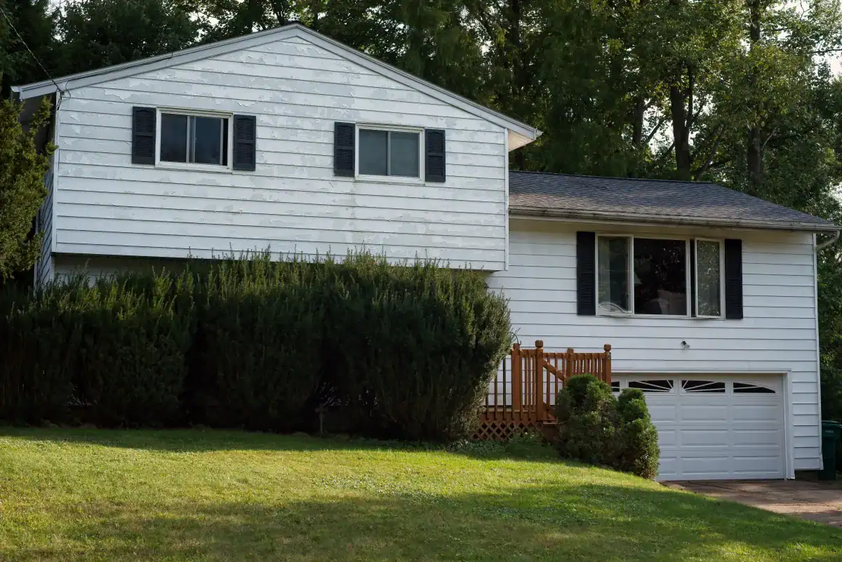 Weathered and faded white exterior paint on a residential home