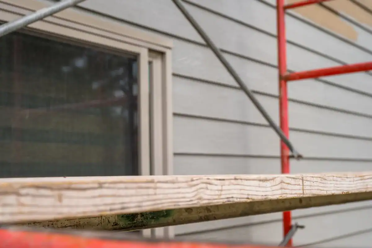 Scaffold set up against house siding for exterior painting project